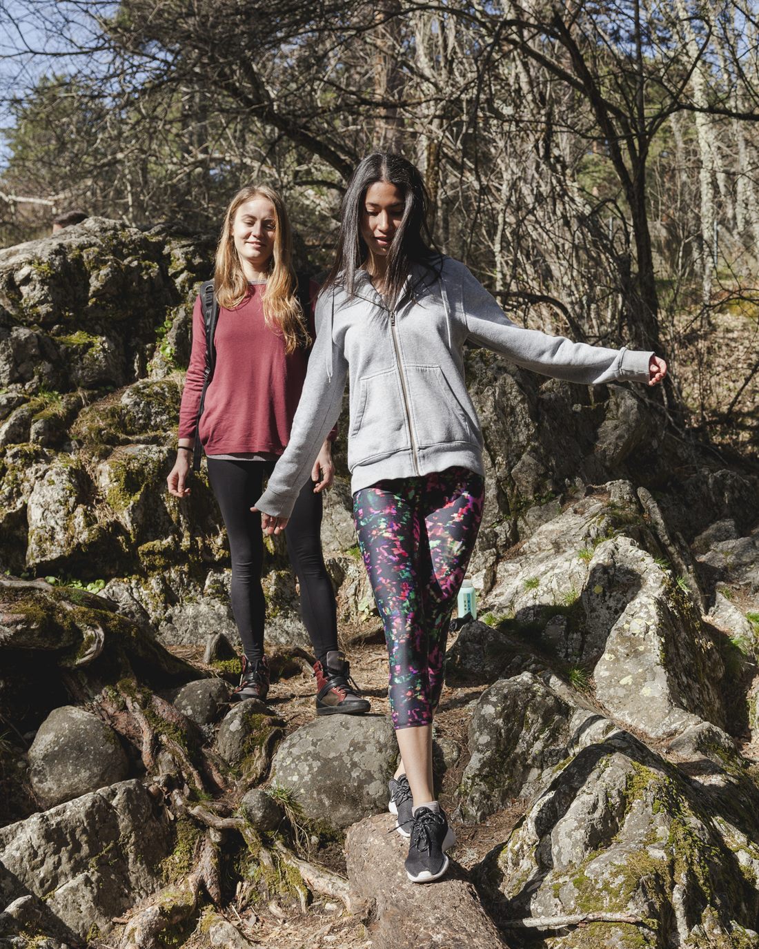 Zwei junge Frauen wandern gemeinsam auf einem Waldweg